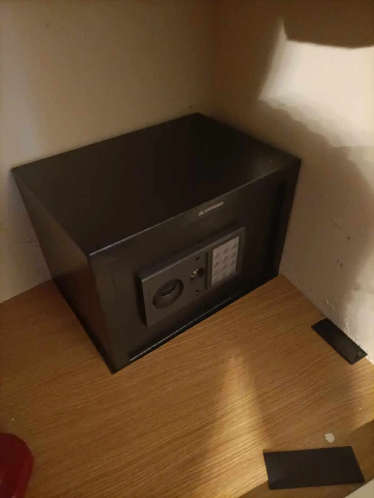 Caja fuerte negra marca Arregui con teclado digital instalada en el interior de un armario de madera